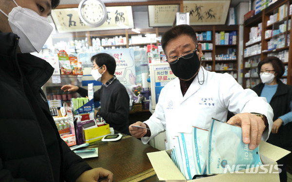 지난 12일 오전 서울 서초구의 한 약국, 시민들에게 공적마스크를 판매하느라 분주한 약사의 모습이다. 사진=뉴시스.