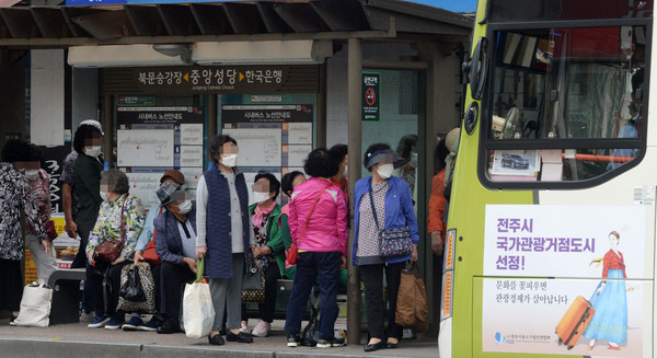 대중교통 이용 승객의 마스크 착용 의무화를 하루 앞둔 25일 전북 전주시 완산구 노송동 팔달로 일대의 버스정류장에서 마스크를 착용한 시민들이 버스를 기다리고 있다. 사진=뉴시스