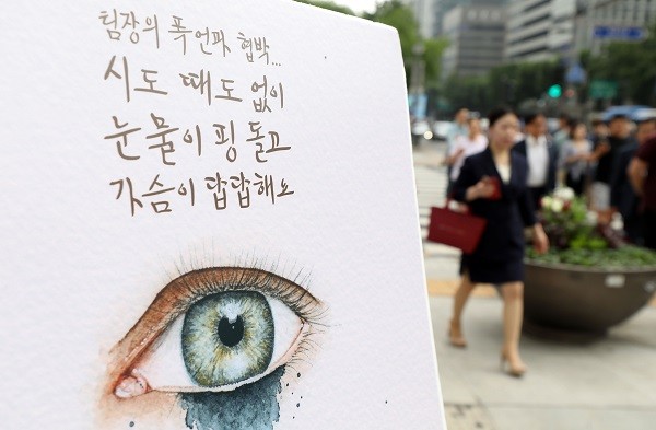 지난해 7월 16일 오전 서울 종로구 광화문 광장 네거리에서 열린 '직장 내 괴롭힘 금지법' 시행 맞이 캠페인에 설치된 판넬 앞을 시민들이 지나고 있다. 사진=뉴시스