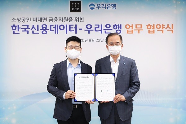 서동립(오른쪽) 우리은행 중소기업그룹장과 김동호(왼쪽) 한국신용데이터 대표이사가 22일 소상공인 비대면 금융지원을 위한 업무협약식에서 기념촬영을 하고 있다. 사진=우리은행