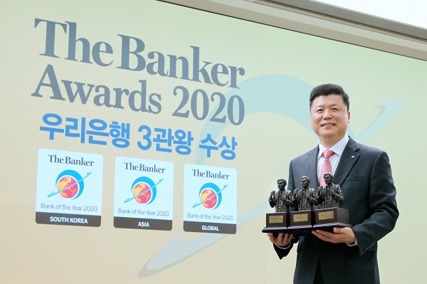 우리은행 권광석 은행장이 3일 온라인으로 진행된 2020년 ‘더 뱅커(The Banker) THE BANK OF THE YEAR’ 시상식에서 3개 부문 수상 트로피를 들고 기념촬영을 하고 있다. 사진=우리은행