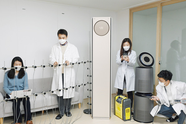 LG전자 연구원들이 서울 금천구 가산R&D캠퍼스에 위치한 공기과학연구소에서 휘센 타워 에어컨의 기류(氣流), 퓨리케어 360˚ 공기청정기 알파의 미세먼지제거능력 등을 시험하고 있다 / 사진=LG전자