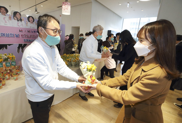 KT 구현모 대표와 최장복 노조위원장이 광화문에 위치한 KT 이스트 사옥에서 여성 임직원에게 꽃을 나눠주고 있다. / 사진=KT