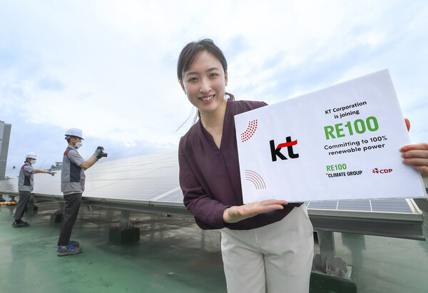 KT구로타워 옥상에 구축된 태양광발전소에서 KT 직원이 RE100 가입을 알리는 기념사진을 촬영하는 모습. 사진=KT 제공